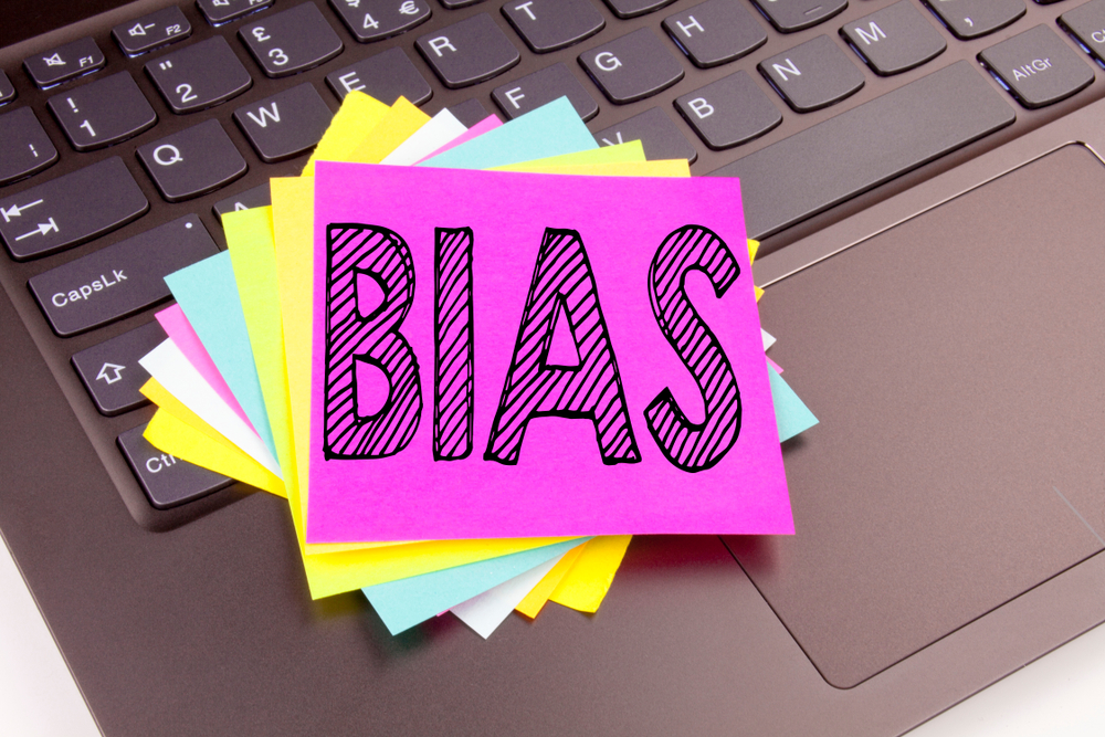 Post-it notes on a laptop saying "bias"