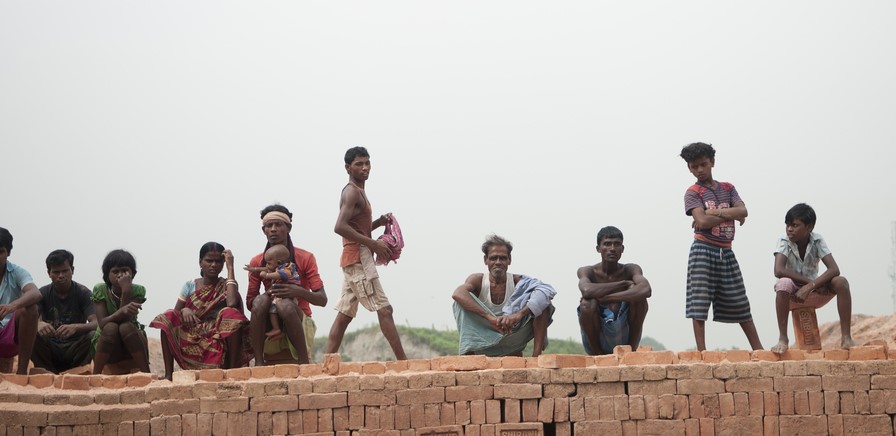 A group of people being kept as modern slaves, including a mother with a baby